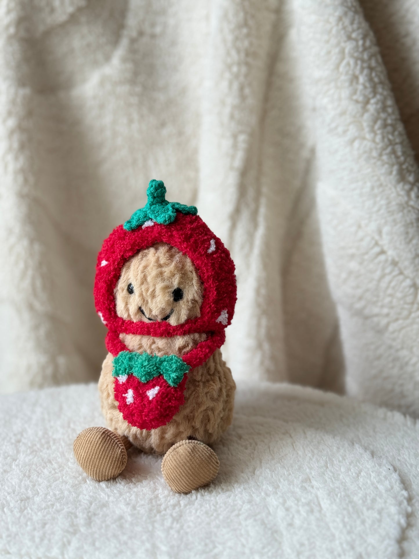Jellycat Peanut styled in a handmade strawberry bonnet and bag set, creating a cute fruit-themed plush look.