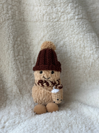 Handmade crochet boba tea outfit for Jellycat Peanut — dark chocolate ribbed bobble hat, striped brown scarf, mini boba cup, front view on cream background